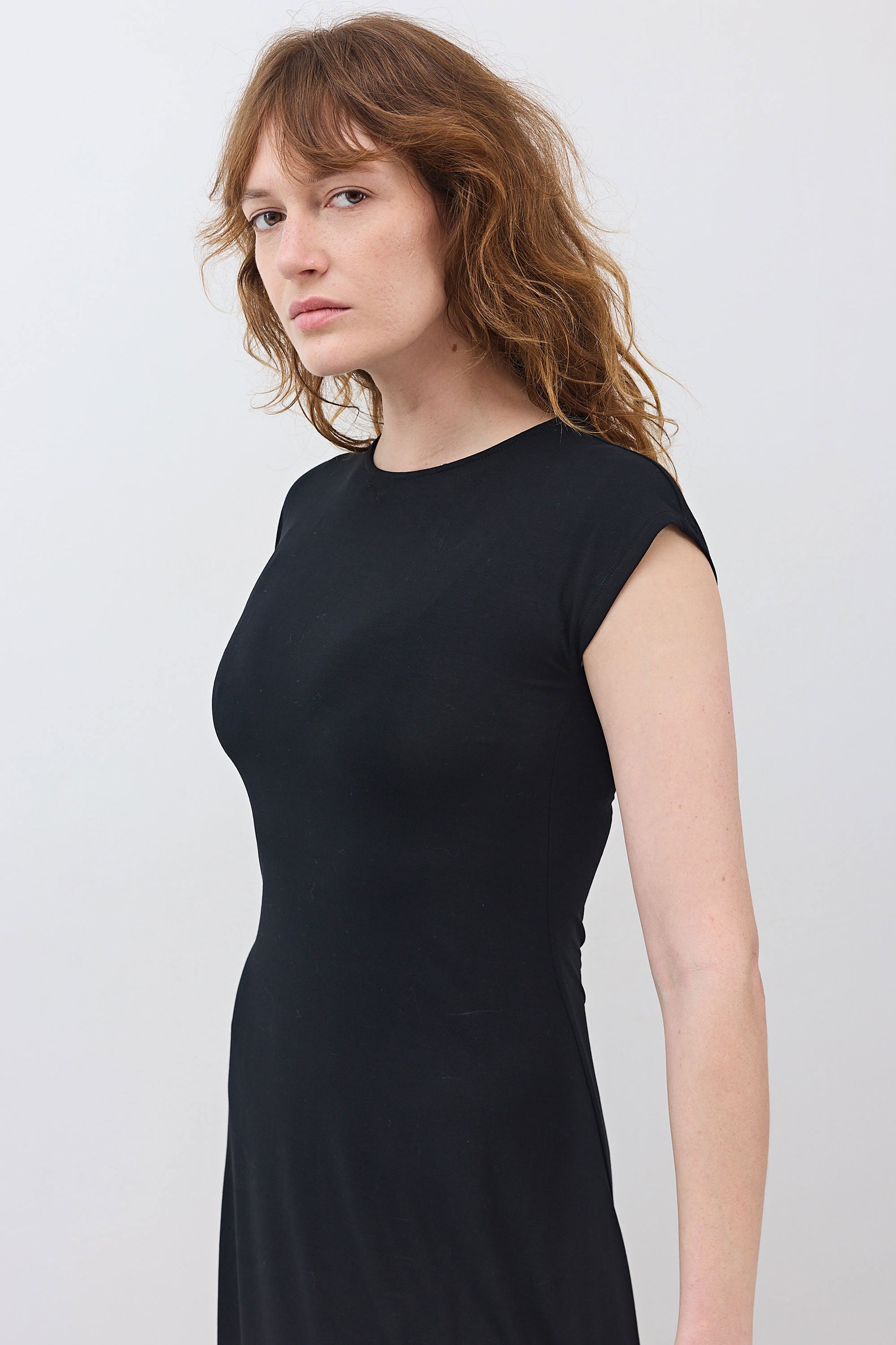 Black short-sleeve jersey dress, close-up of neckline and fitted bodice