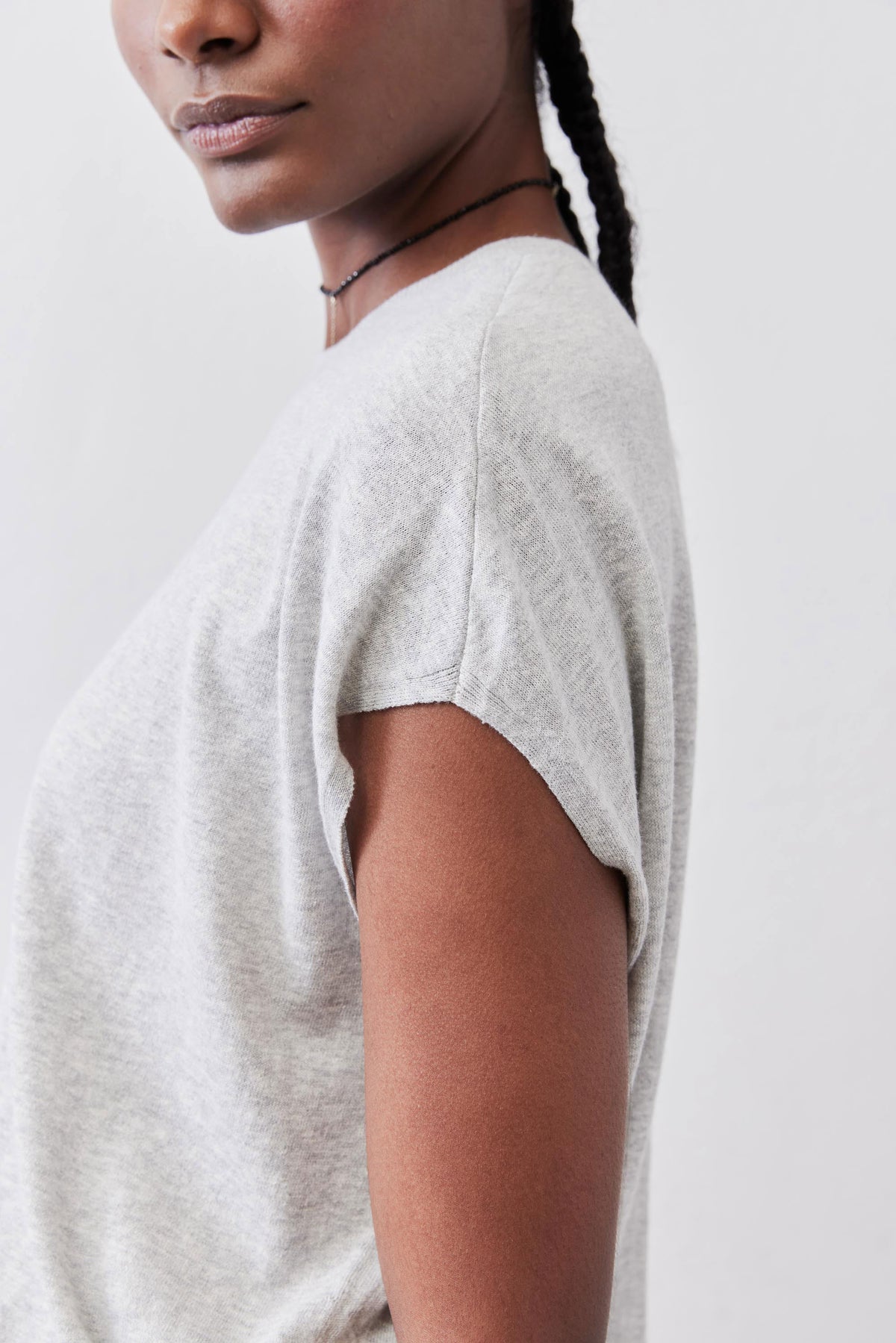Light sweater top in heather light gray, close side view at crew neckline