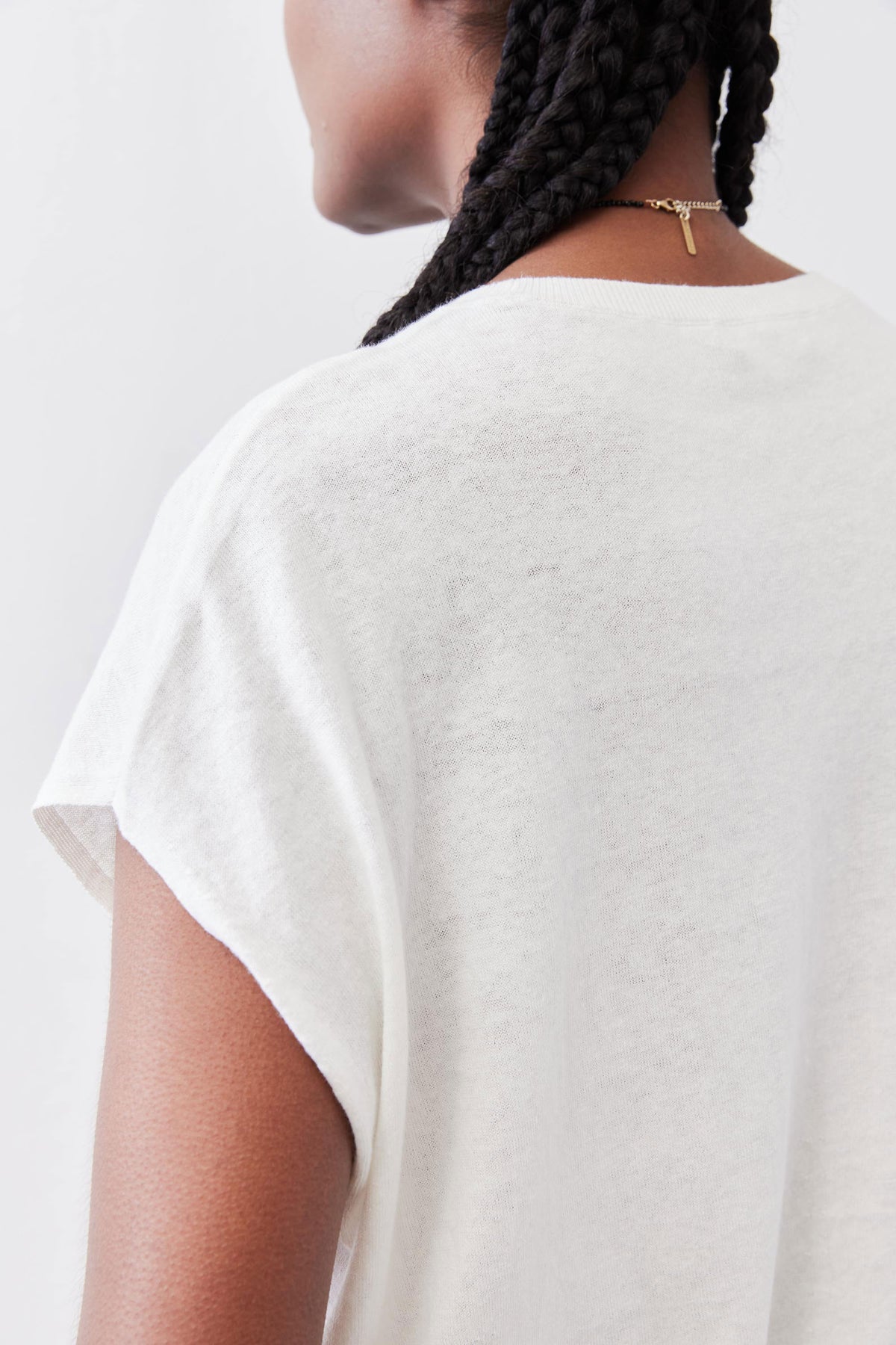 White light sweater top, back view detail at short sleeve and neckline