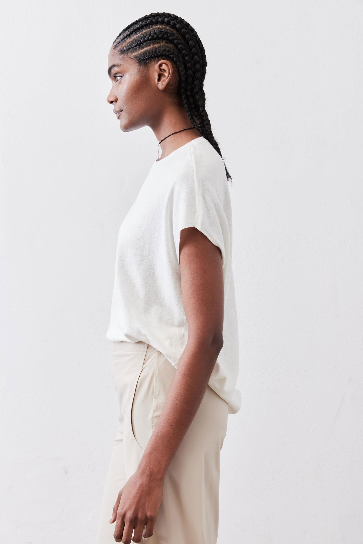 White light sweater top with short sleeves and crew neckline, back/side view