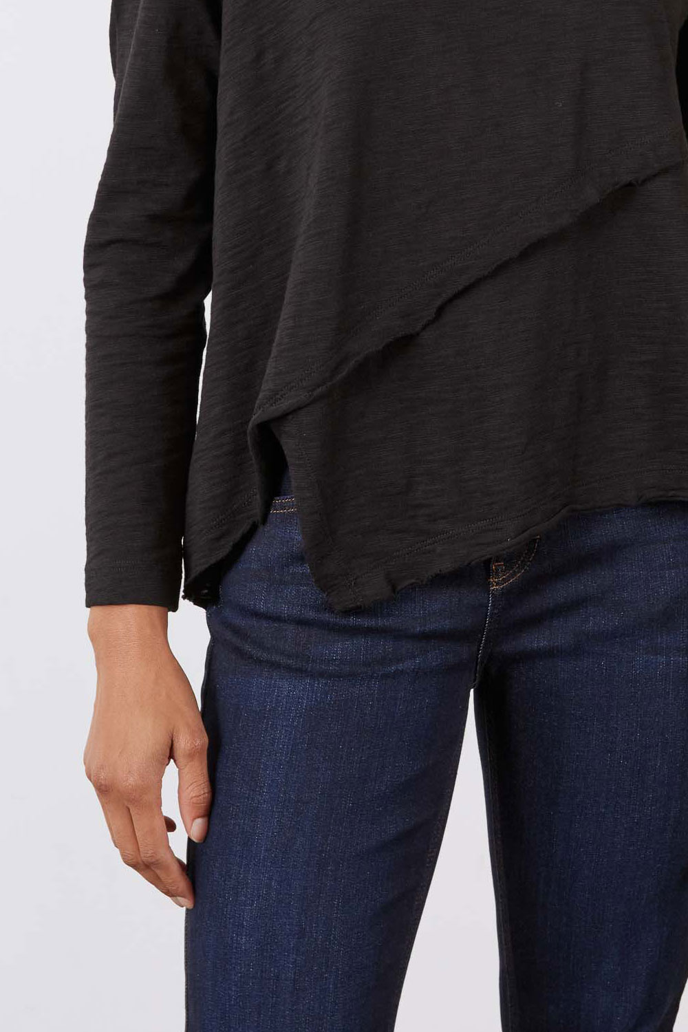Black asymmetric long sleeve top with diagonal wrap front and hi-low hem