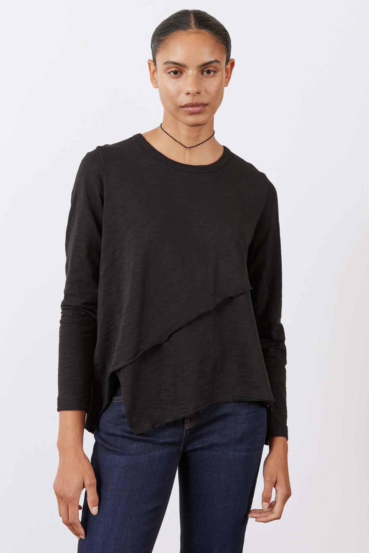 Black asymmetric long sleeve top with diagonal drape and crew neck