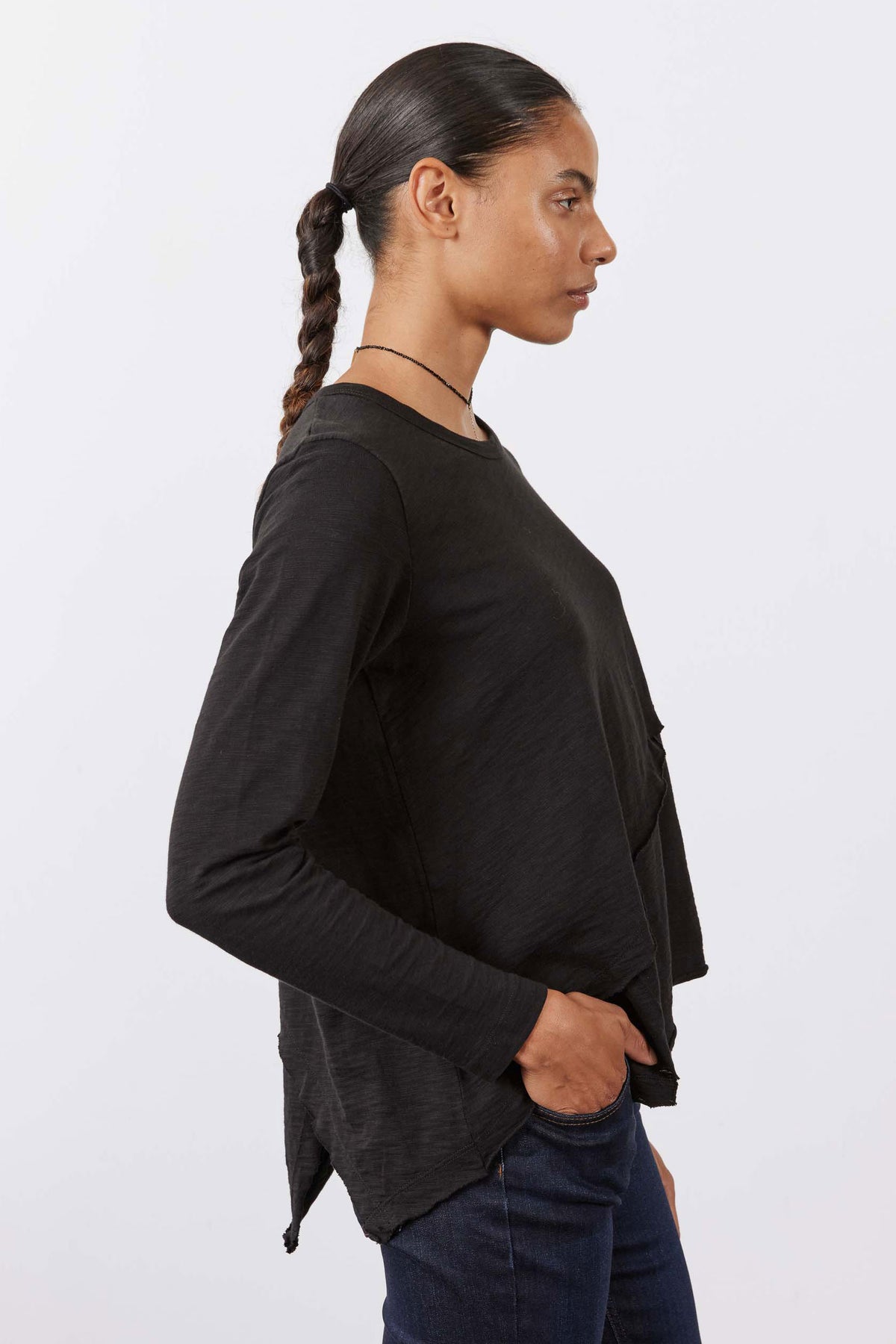 Black asymmetric long sleeve top, draped diagonal front detail, side view