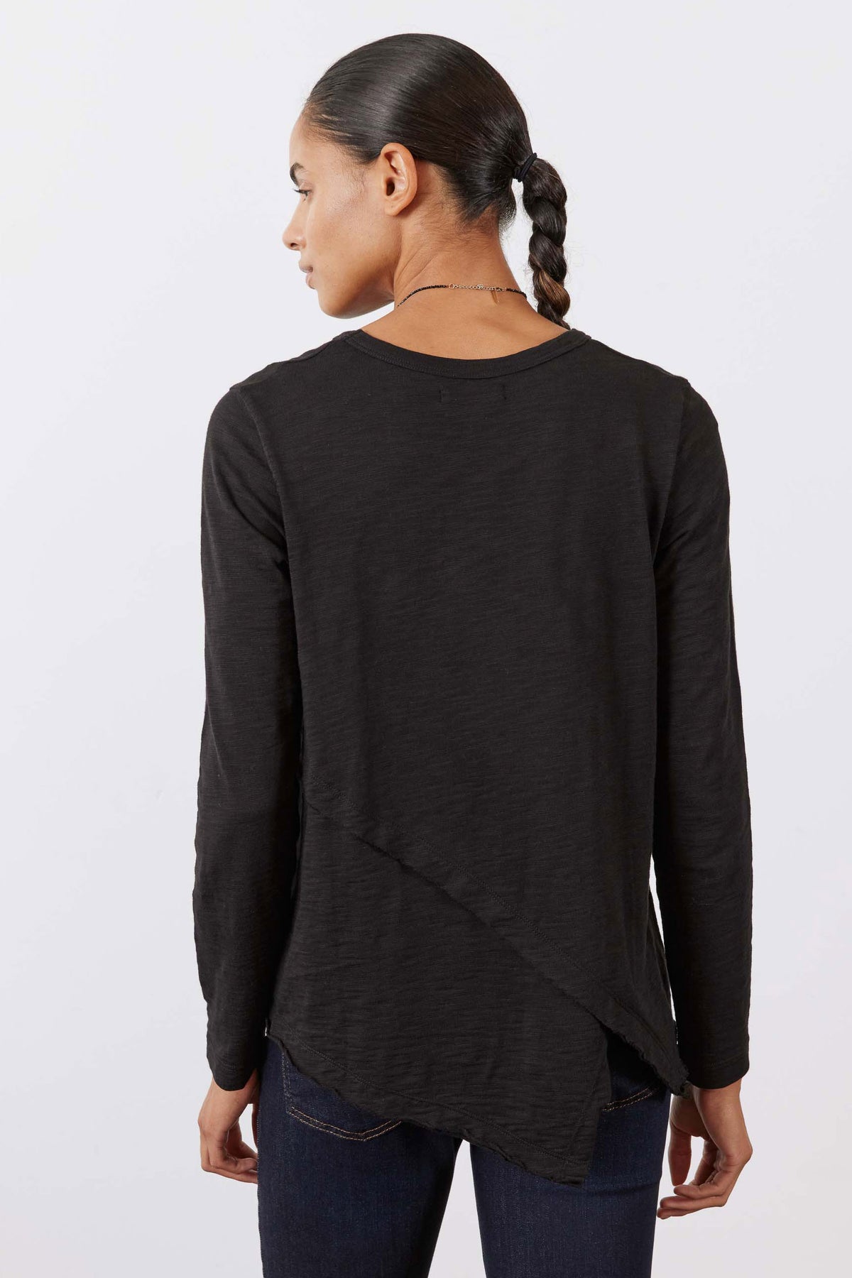 Black asymmetric long sleeve top, back view with curved diagonal drape hem