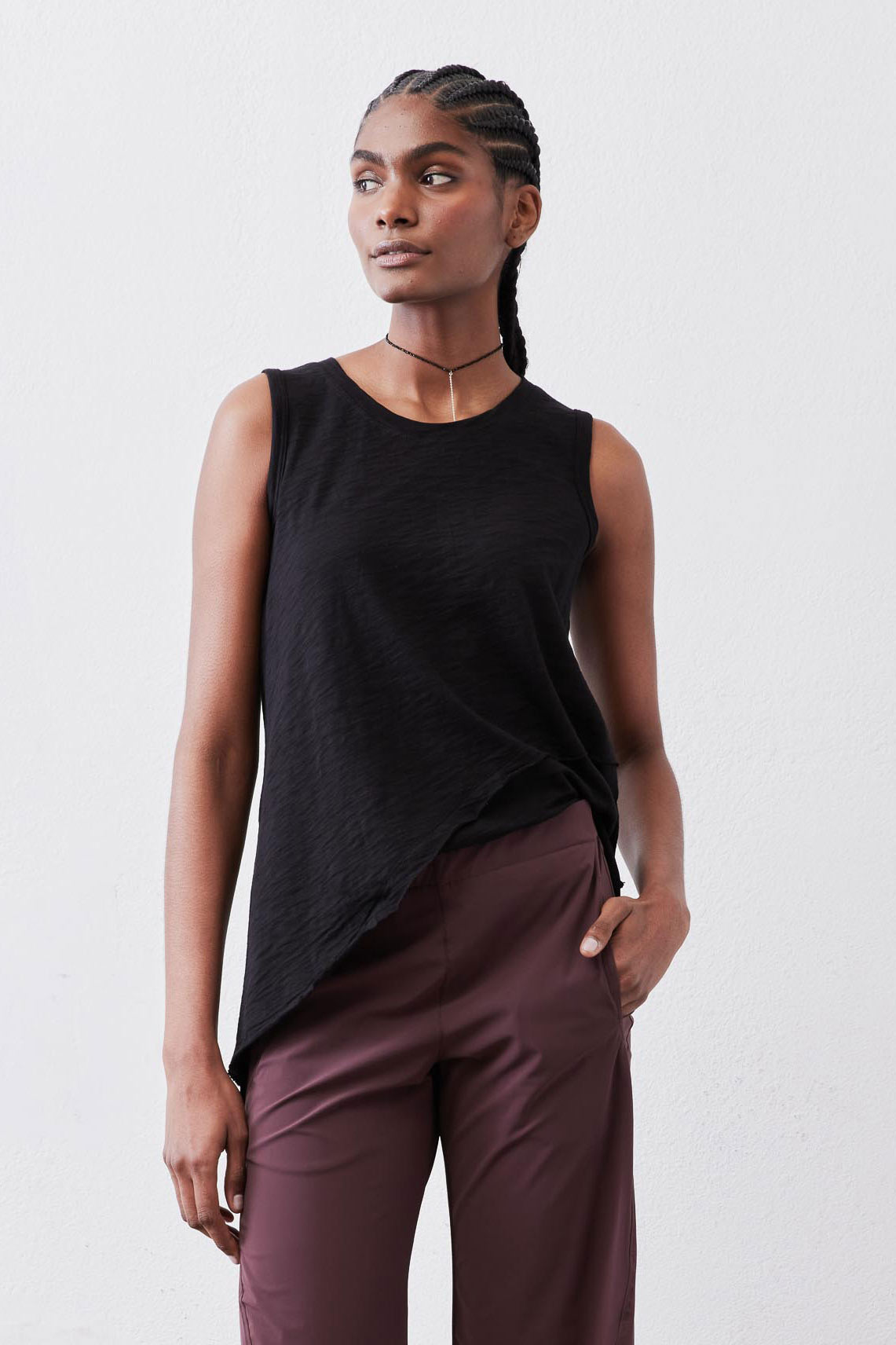 Black asymmetric tank top with diagonal drape hem, sleeveless front view.