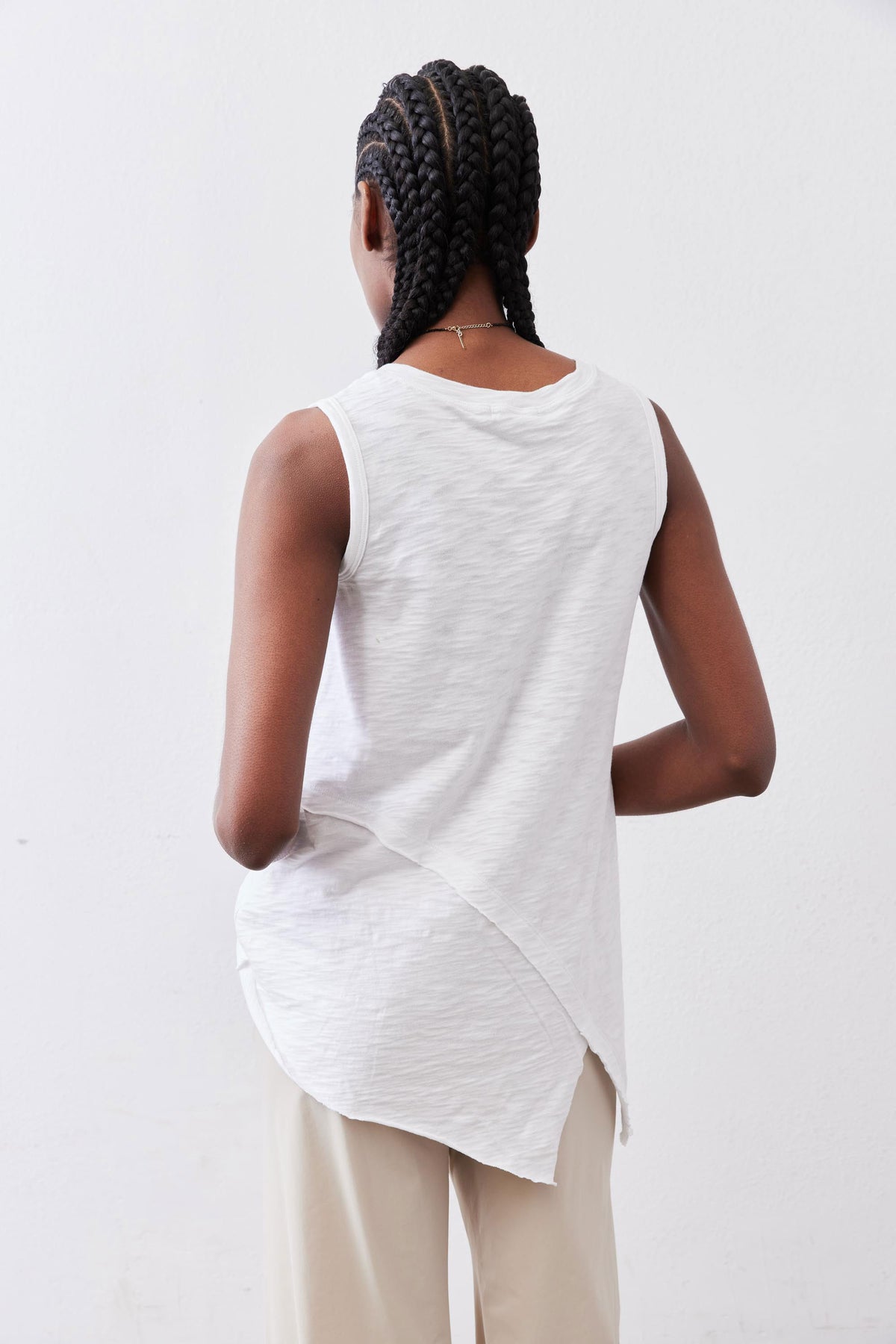 White sleeveless tank top with high-low asymmetric back hem drape