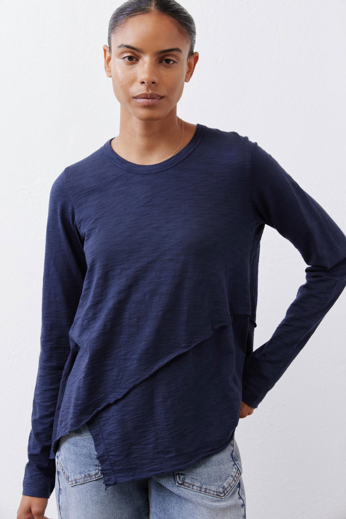Navy asymmetric long sleeve top with crew neck and diagonal drape hem