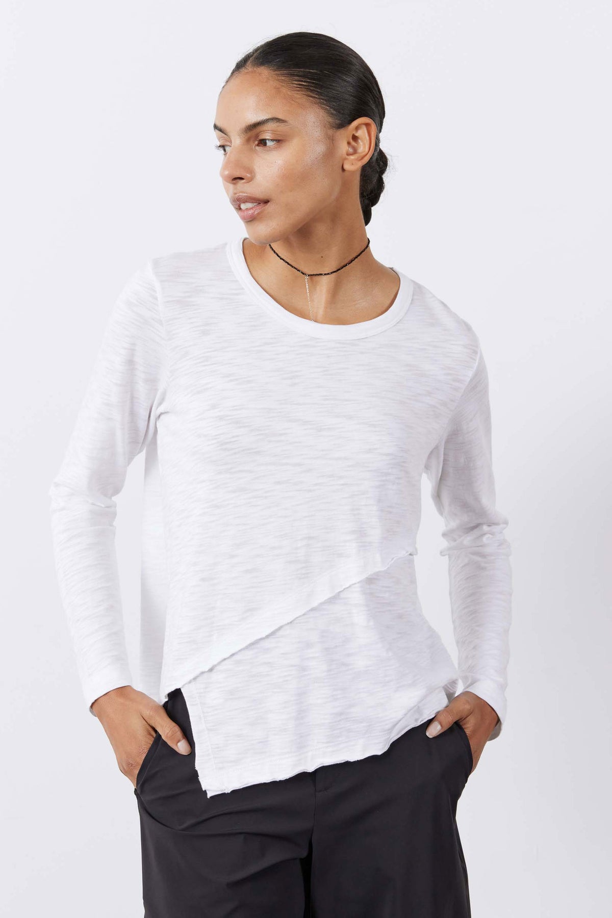 White heathered asymmetric long sleeve top with crew neck and angled side hem