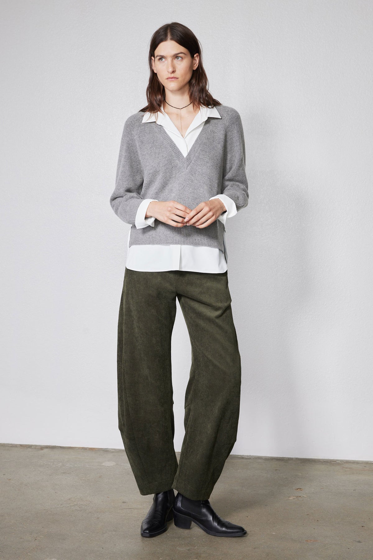 Gray pullover sweater with white collared shirt underneath and layered hem and cuffs