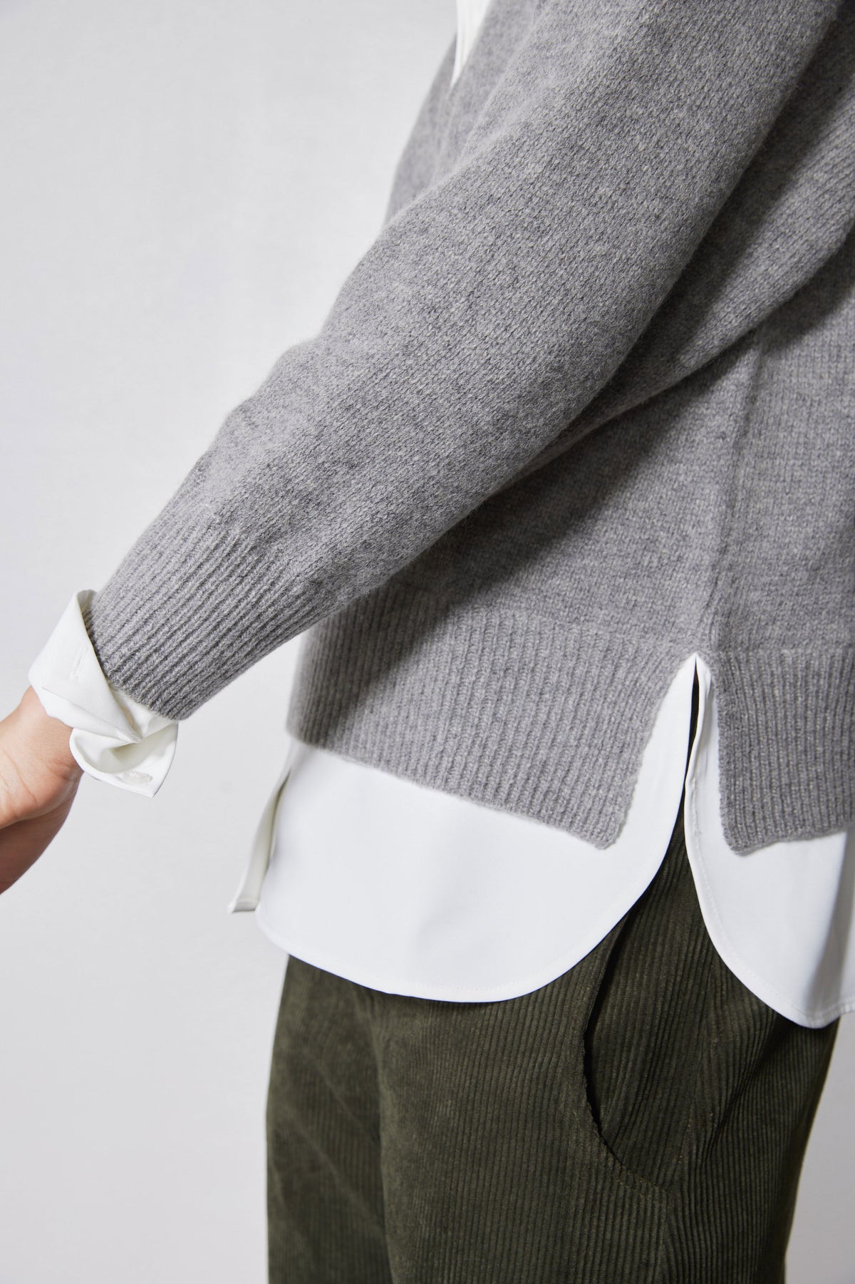Gray pullover sweater with ribbed knit cuffs and hem over a white shirt