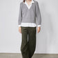 Gray sweater pullover layered over white shirt; V-neck with visible collar and cuffs