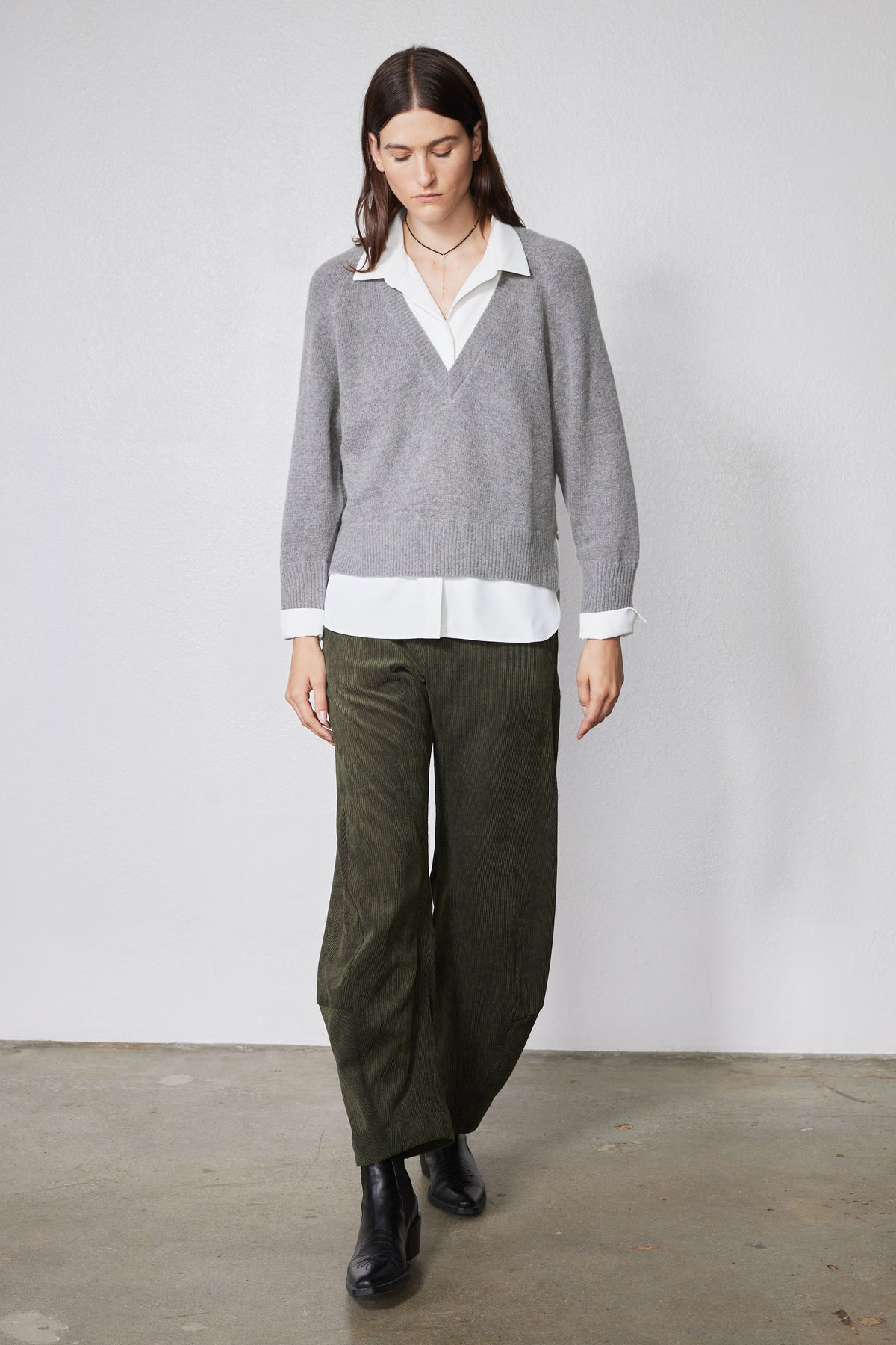 Gray sweater pullover layered over white shirt; V-neck with visible collar and cuffs