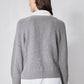 Back view of gray knit pullover sweater with ribbed hem and white shirt layer