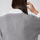 Close-up of gray sweater back with vertical rib knit and white shirt collar edge