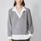 Gray V-neck pullover sweater with white collared shirt layer and ribbed cuffs