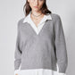 Front view of gray pullover sweater with white shirt placket detail at V-neck hem