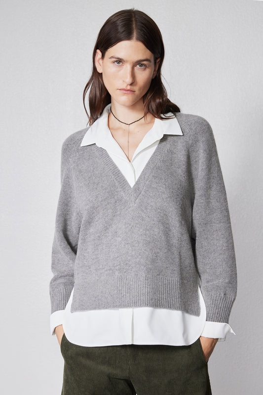 Front view of gray pullover sweater with white shirt placket detail at V-neck hem