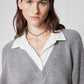 Close-up of gray sweater and white collared shirt at V-neck with layered neckline