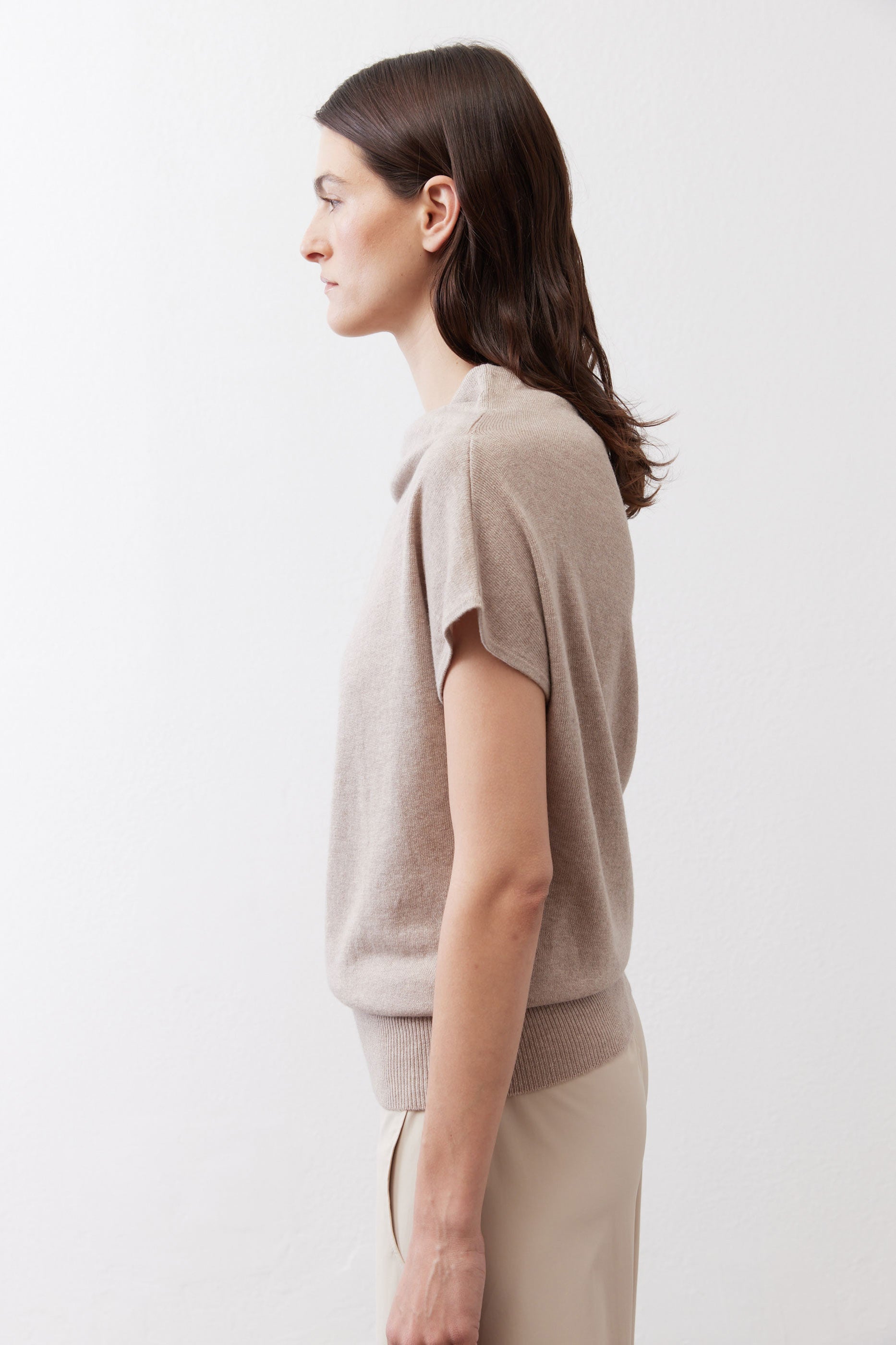 Misty gray short-sleeve sweater from side view with draped cowl neckline