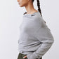 Silver heather knit sweater, long sleeves, side back view with ribbed cuffs.