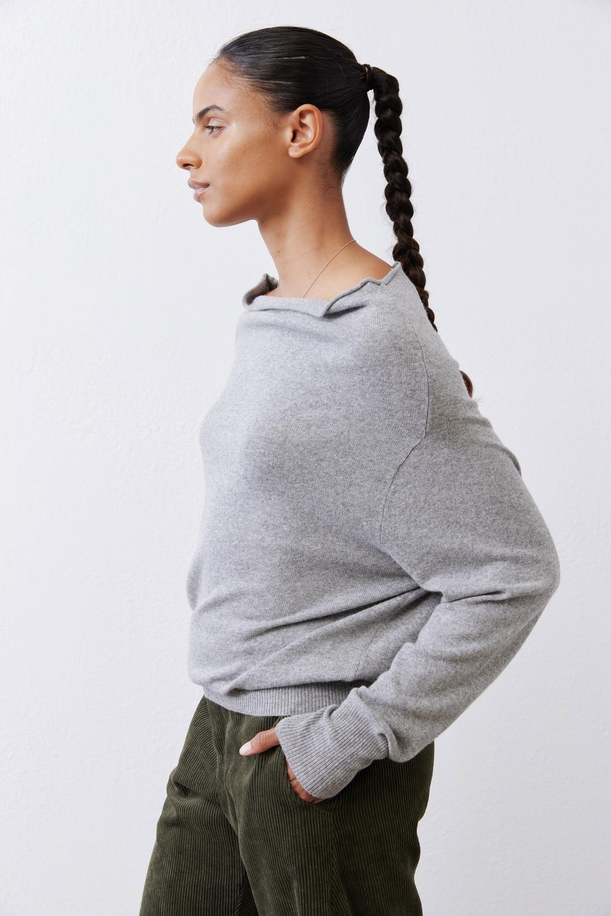 Silver heather knit sweater, long sleeves, side back view with ribbed cuffs.