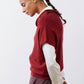Dark cherry short-sleeve sweater in side profile with draped cowl neck