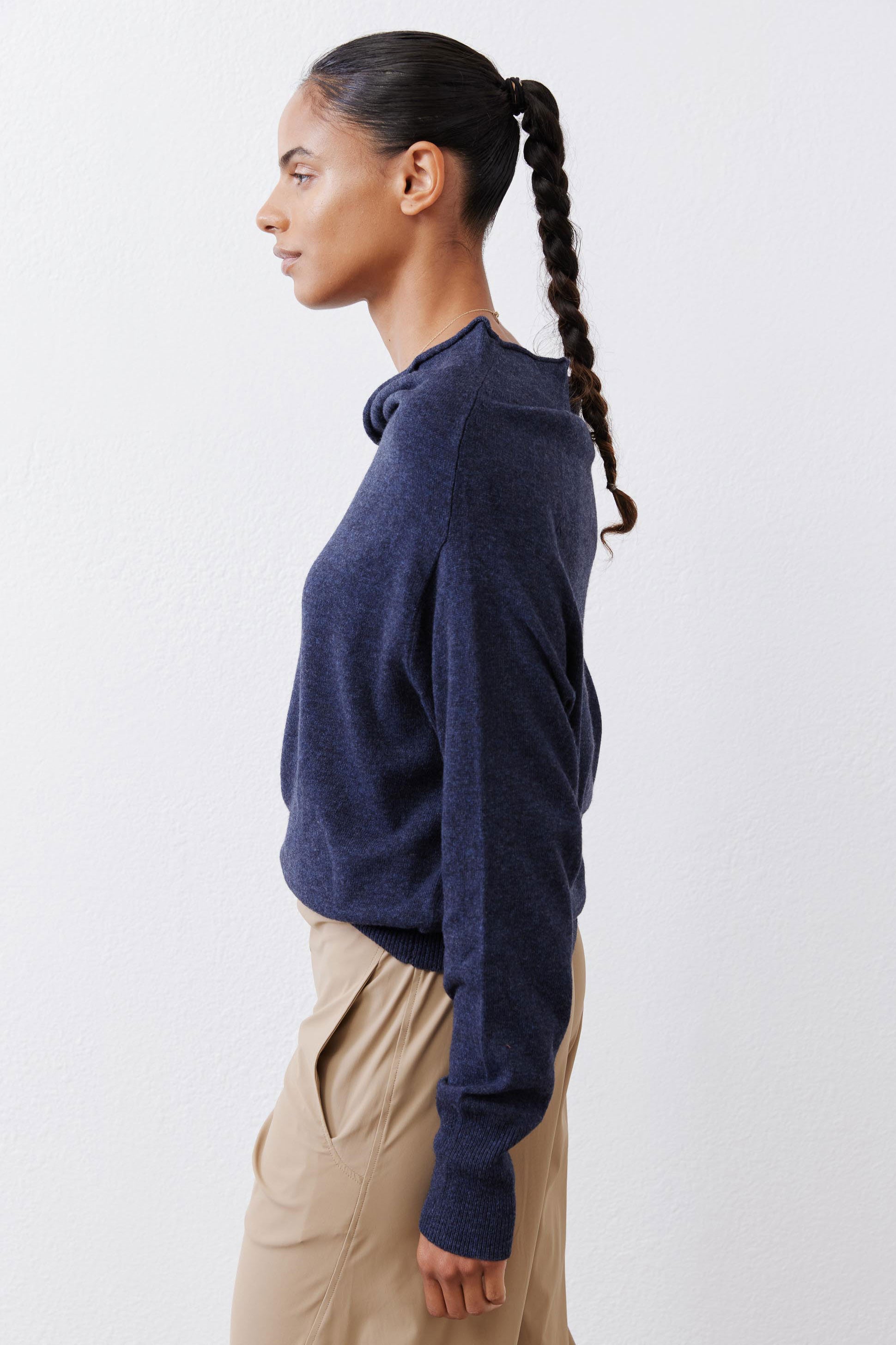Navy cowl-neck sweater side profile with long sleeves and relaxed hem