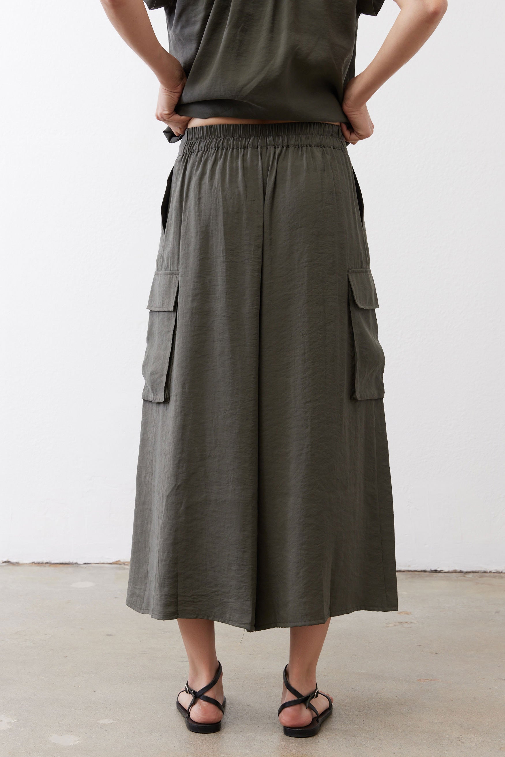 Olive cargo skirt pants back view with elastic waistband and cargo pockets