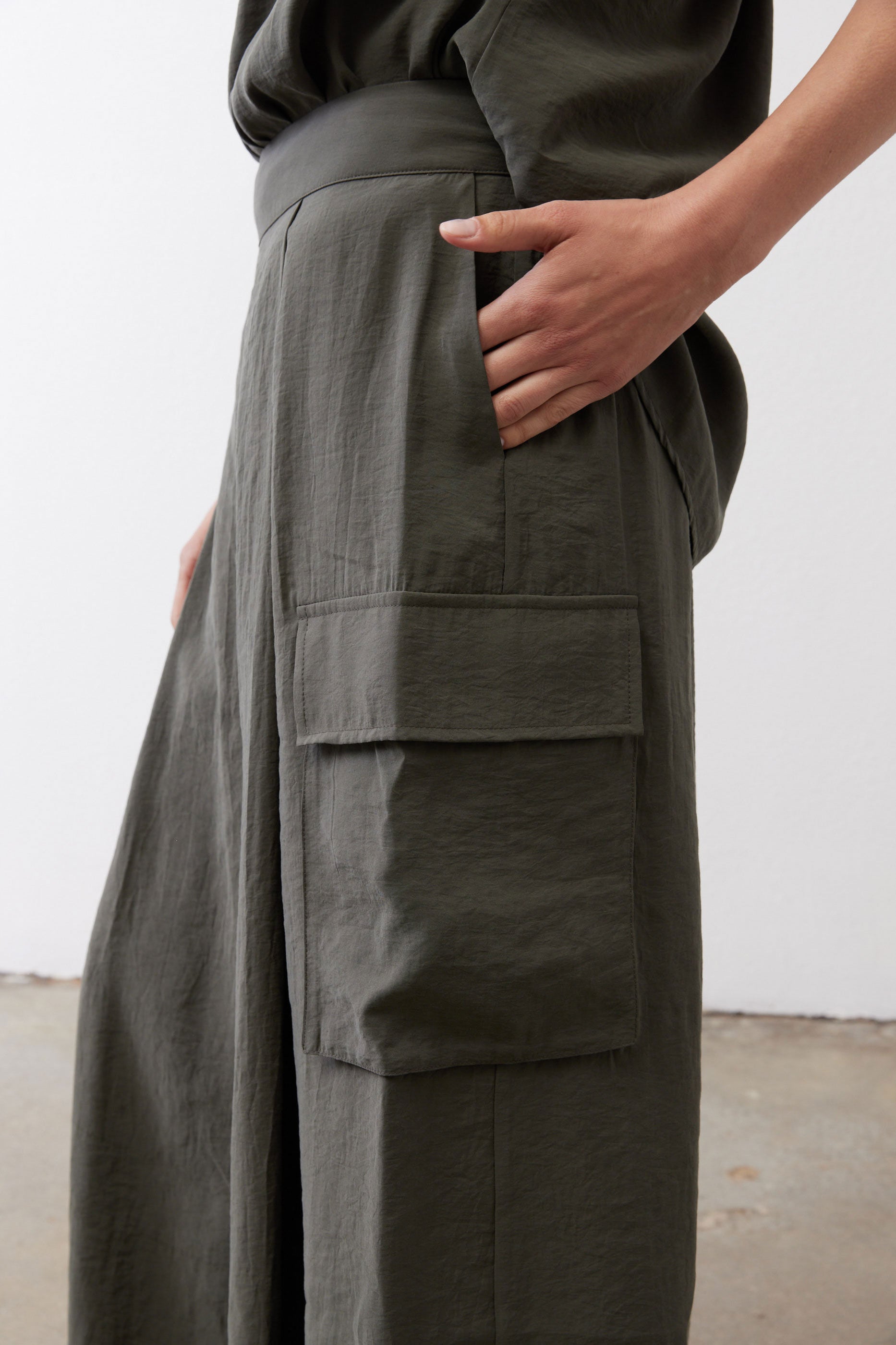 Olive cargo skirt pants with large front patch pockets and flap details