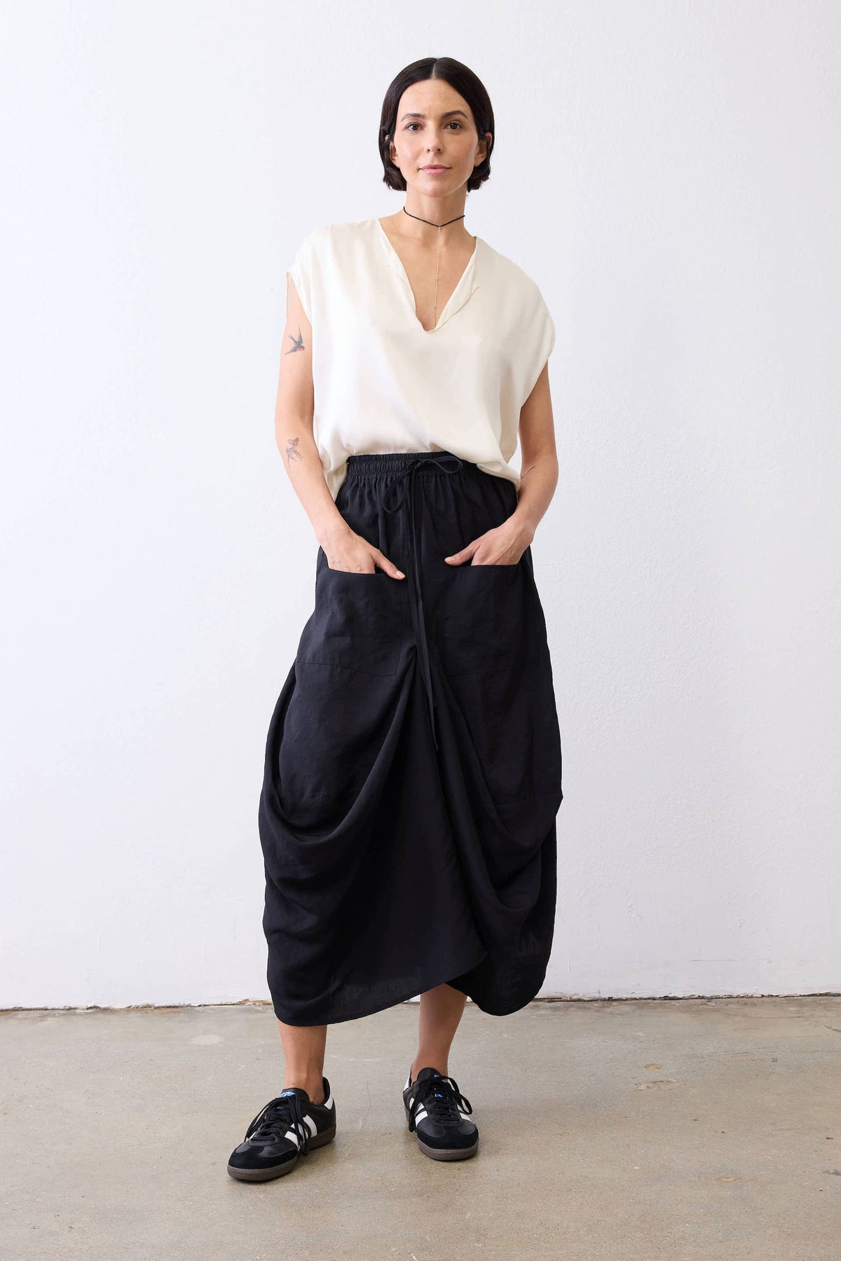 Black ruched-waist midi skirt with gathered folds and draped front
