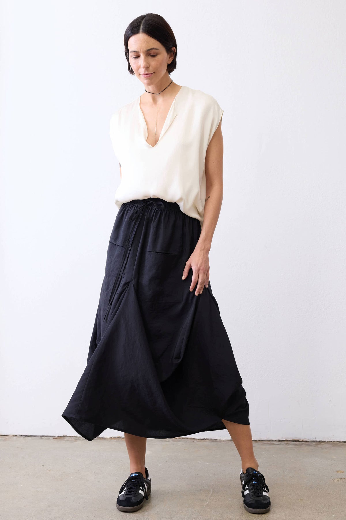 Black midi skirt with elastic waistband and gathered draped silhouette