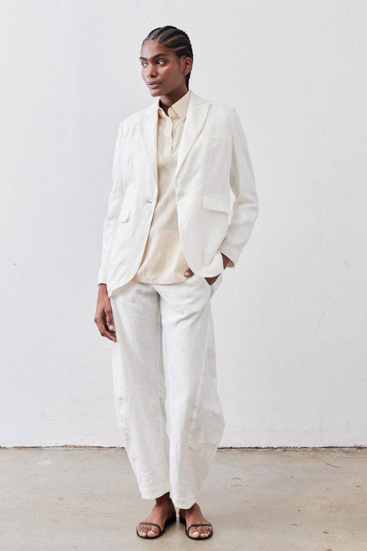 Vintage white linen blazer with notch lapels and flap pockets, worn with light shirt and pants