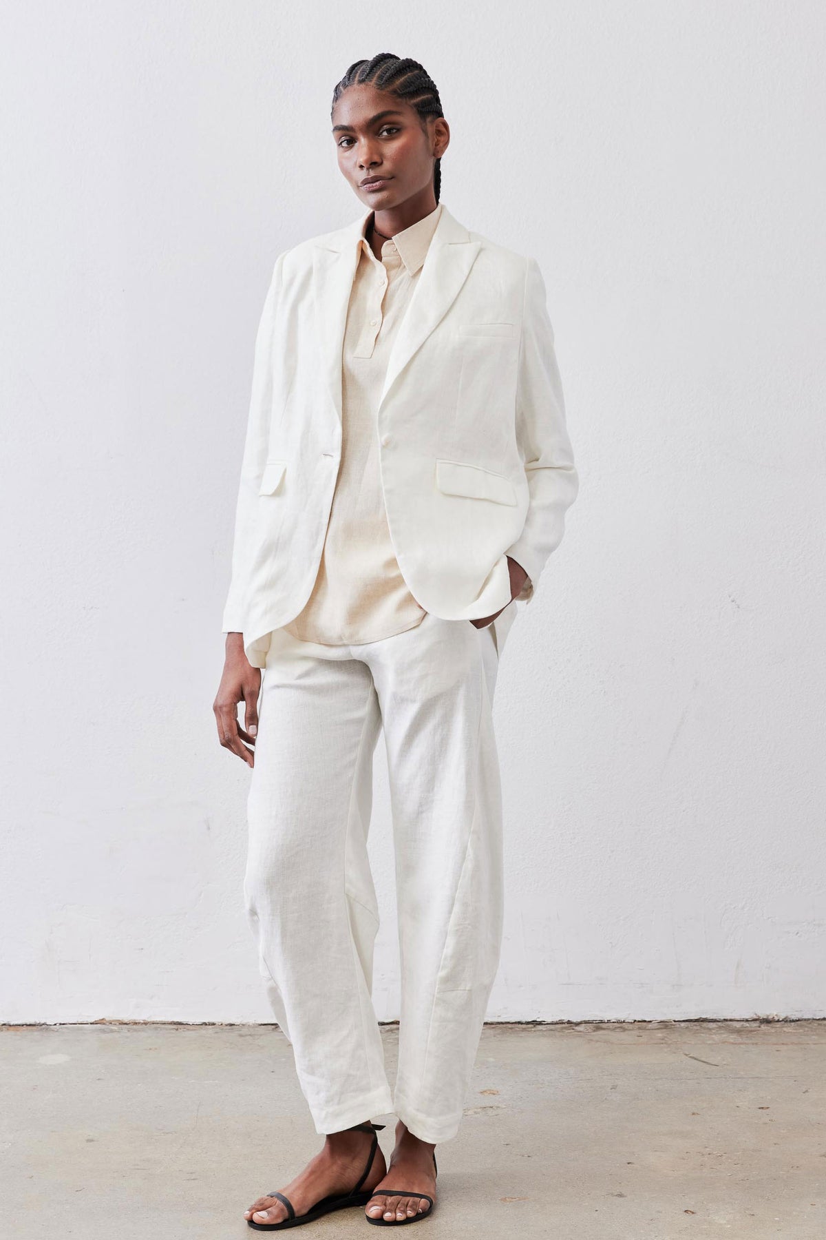 Vintage white linen blazer with notch lapels and flap pockets, relaxed tailored fit on model