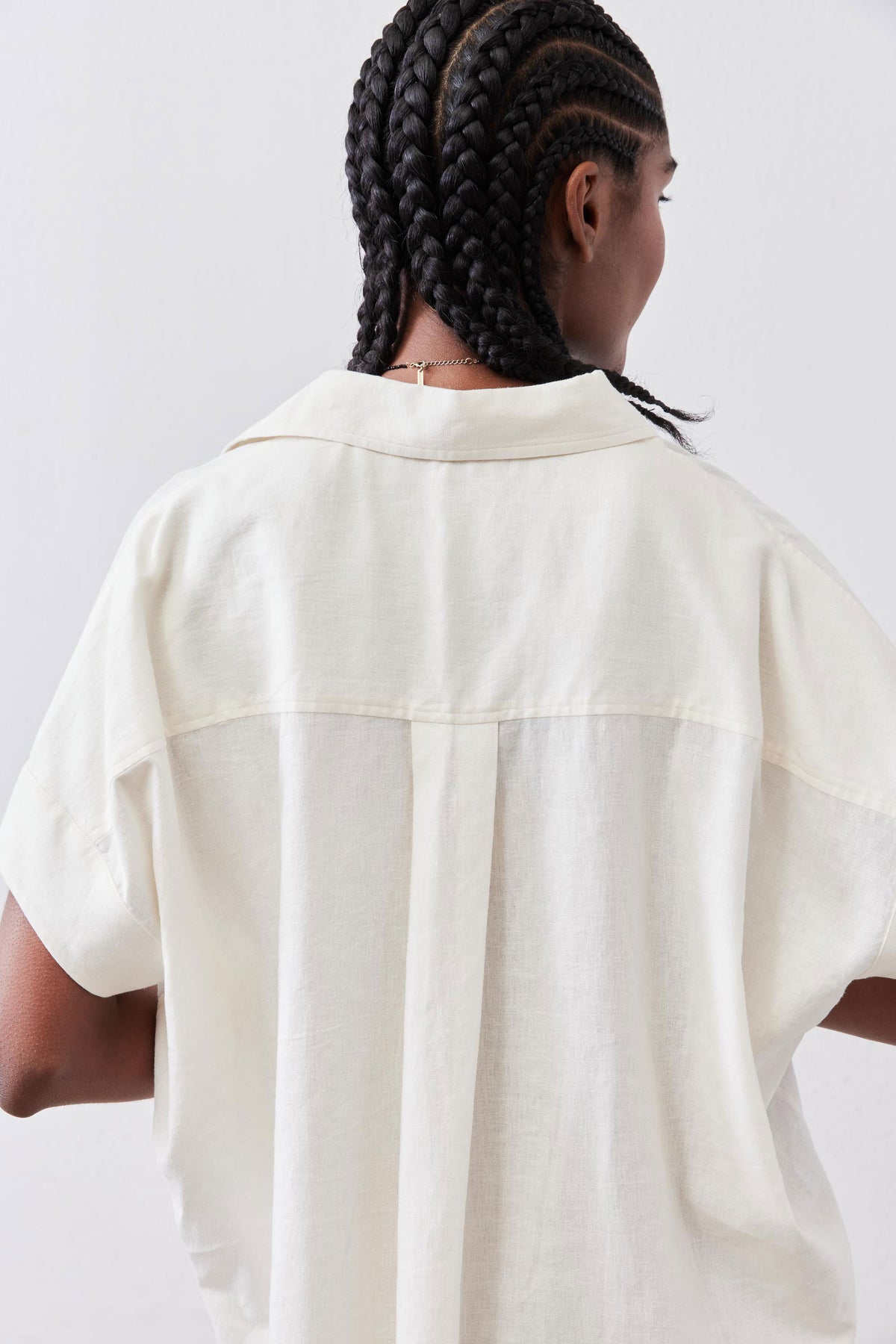Back close-up of vintage white linen pullover blouse with yoke seam and short sleeves