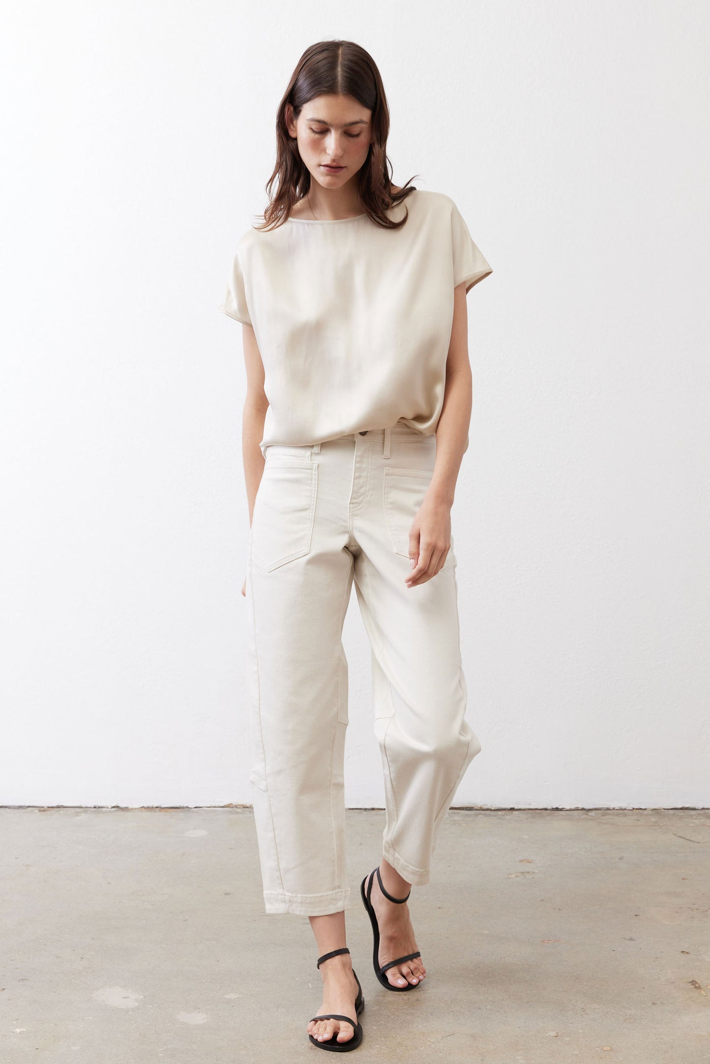Off-white silk blouse with crew neck and short sleeves, worn untucked
