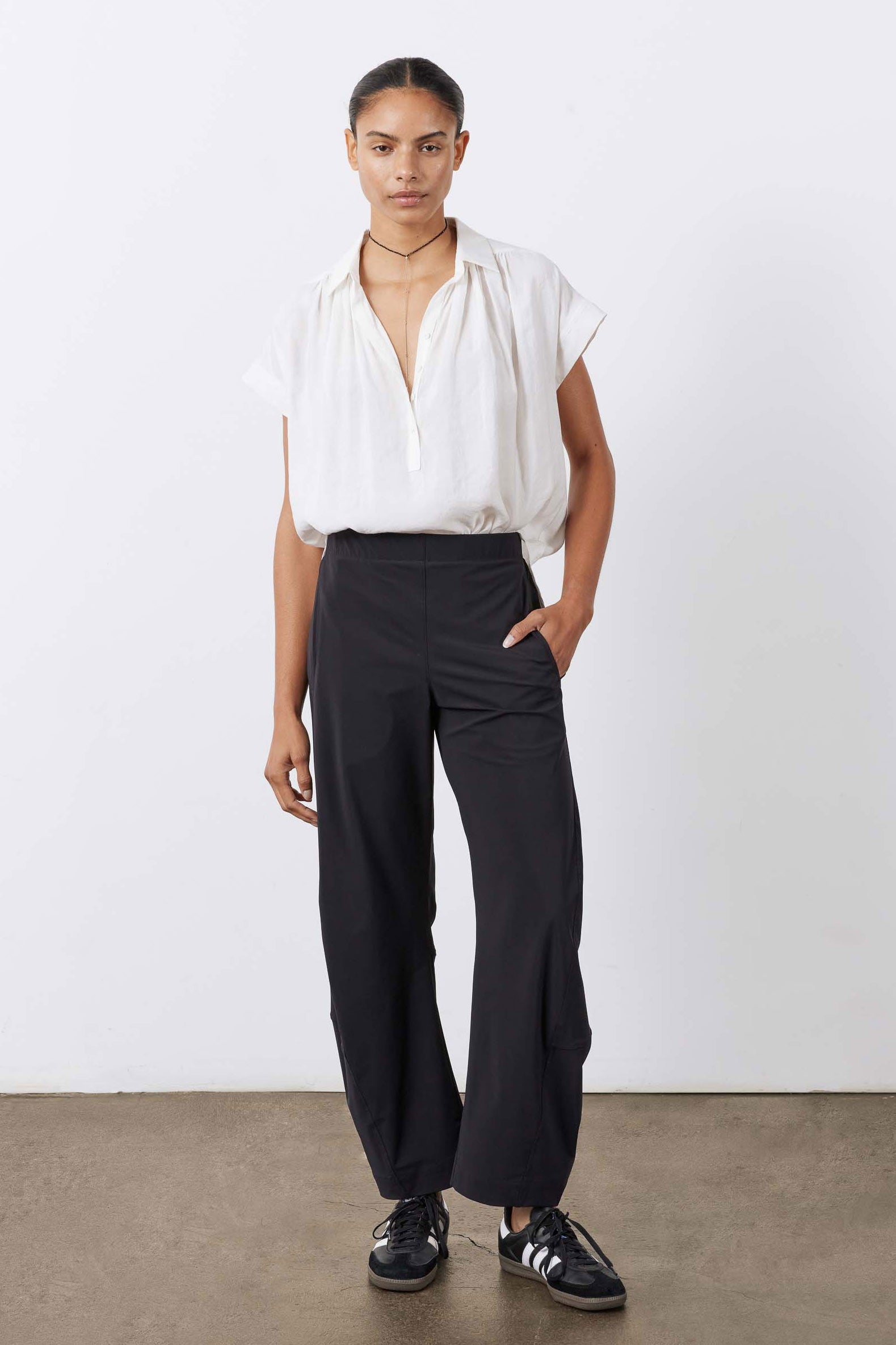 Black work pants with relaxed loose legs and elastic waistband, full-length front view