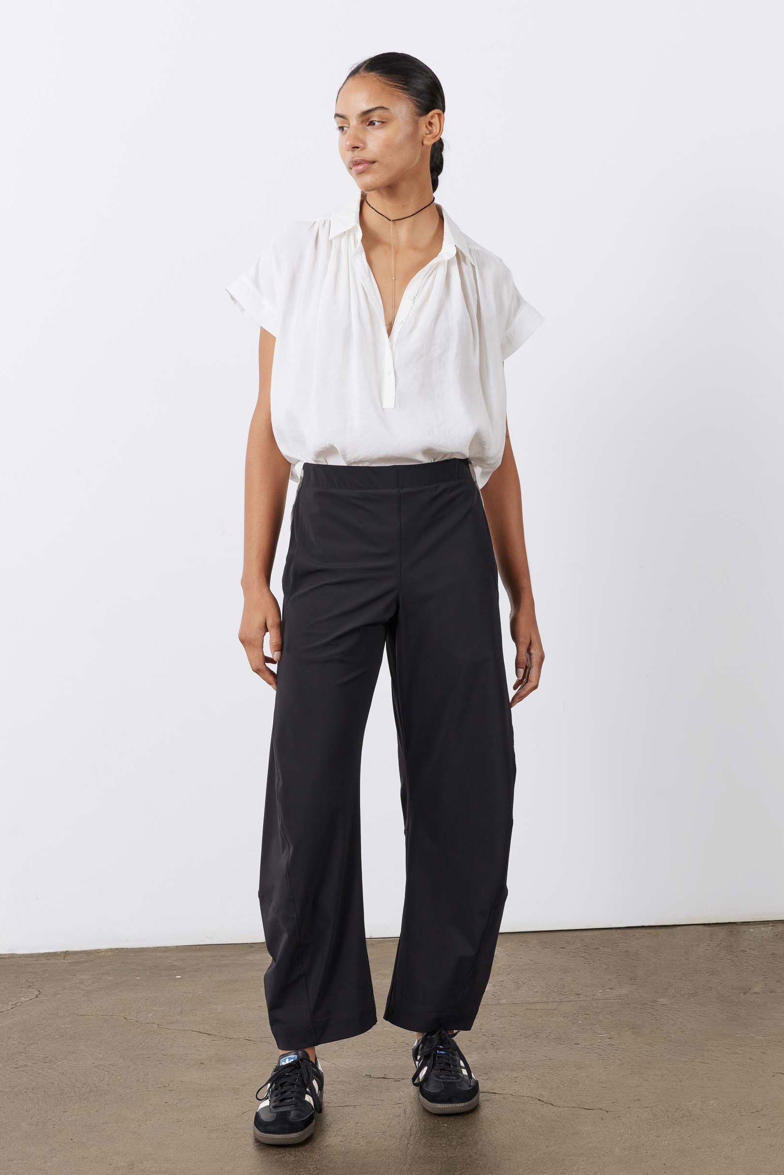 Black work pants with relaxed wide legs and elastic waistband, standing front view