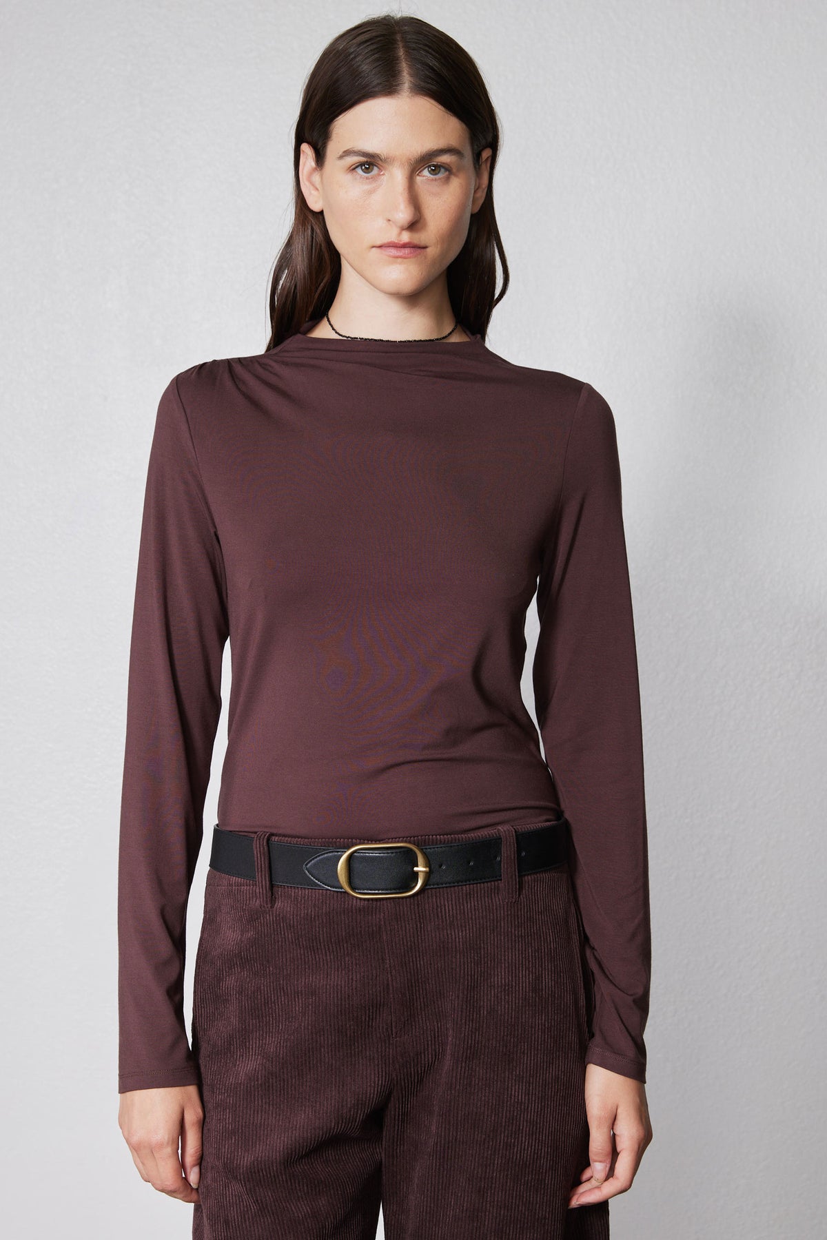 Brown long-sleeve mock-neck top with shoulder seam detailing and straight hem