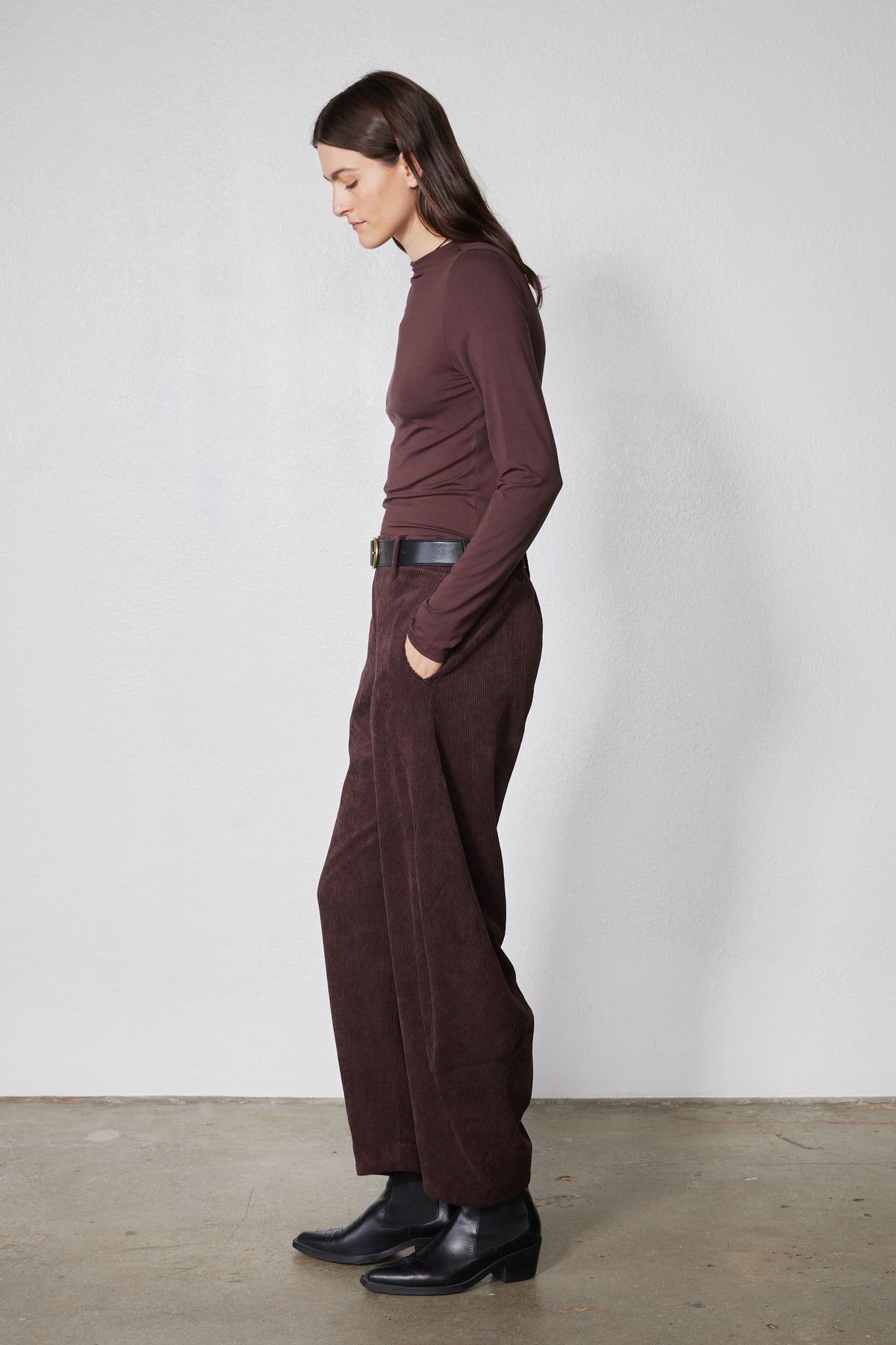 Brown long-sleeve mock-neck top with shoulder seam detailing, side profile