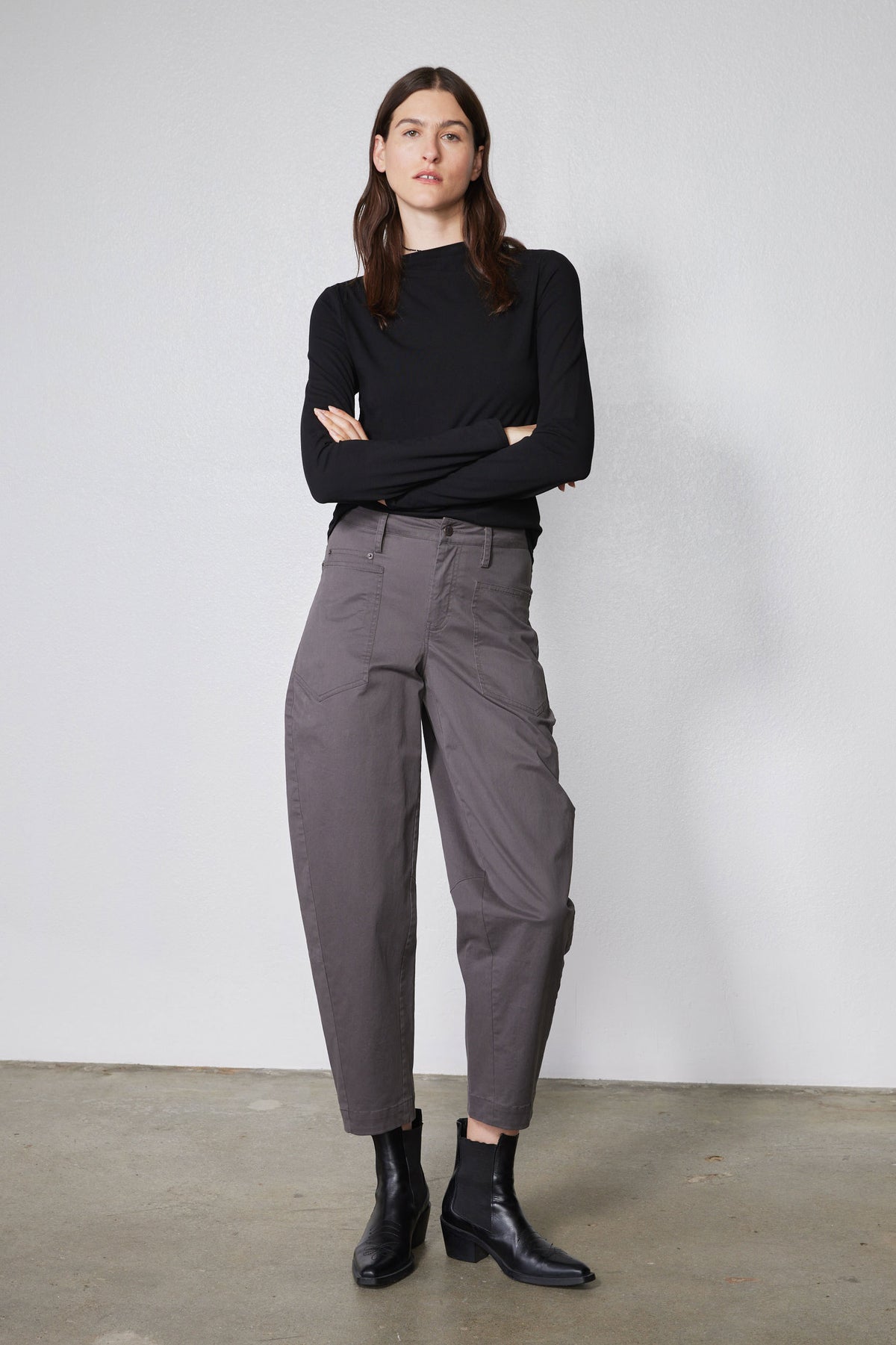 Black long-sleeve top with high neckline and shoulder seam detail, fitted