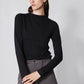 Black long-sleeve top with high neck and shoulder seam detail, side profile
