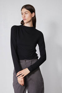 Black long-sleeve top with high neck and shoulder seam detail, side profile
