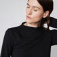 Black long-sleeve top close-up: high neck and shoulder seam detail