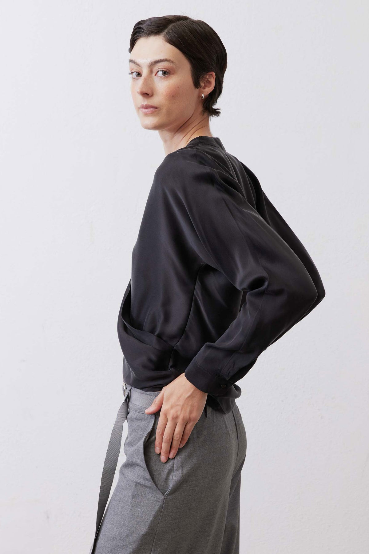 Black long sleeve wrap silk blouse with V-neck and draped side silhouette