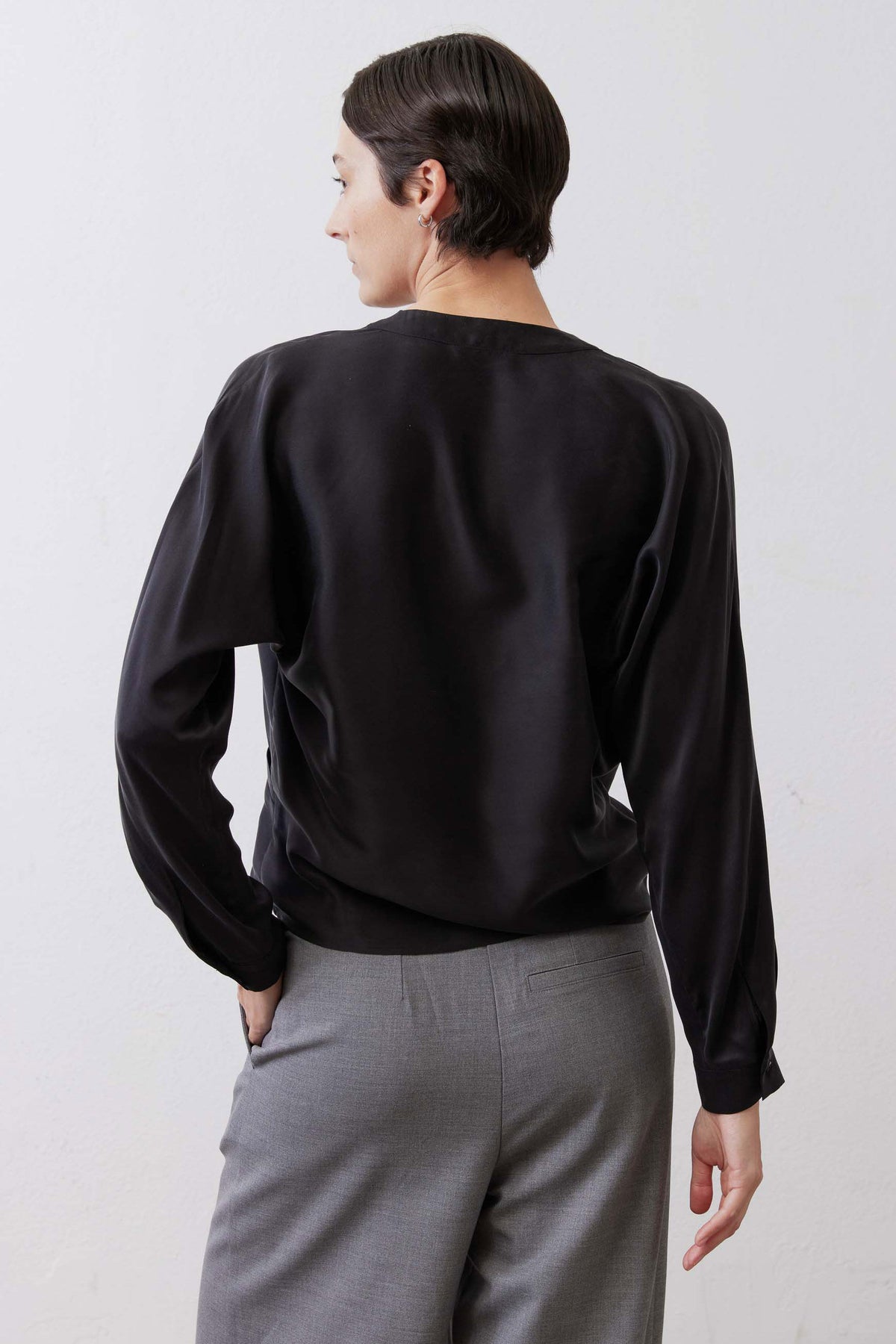 Black long sleeve wrap silk blouse, back side view with wrap silhouette