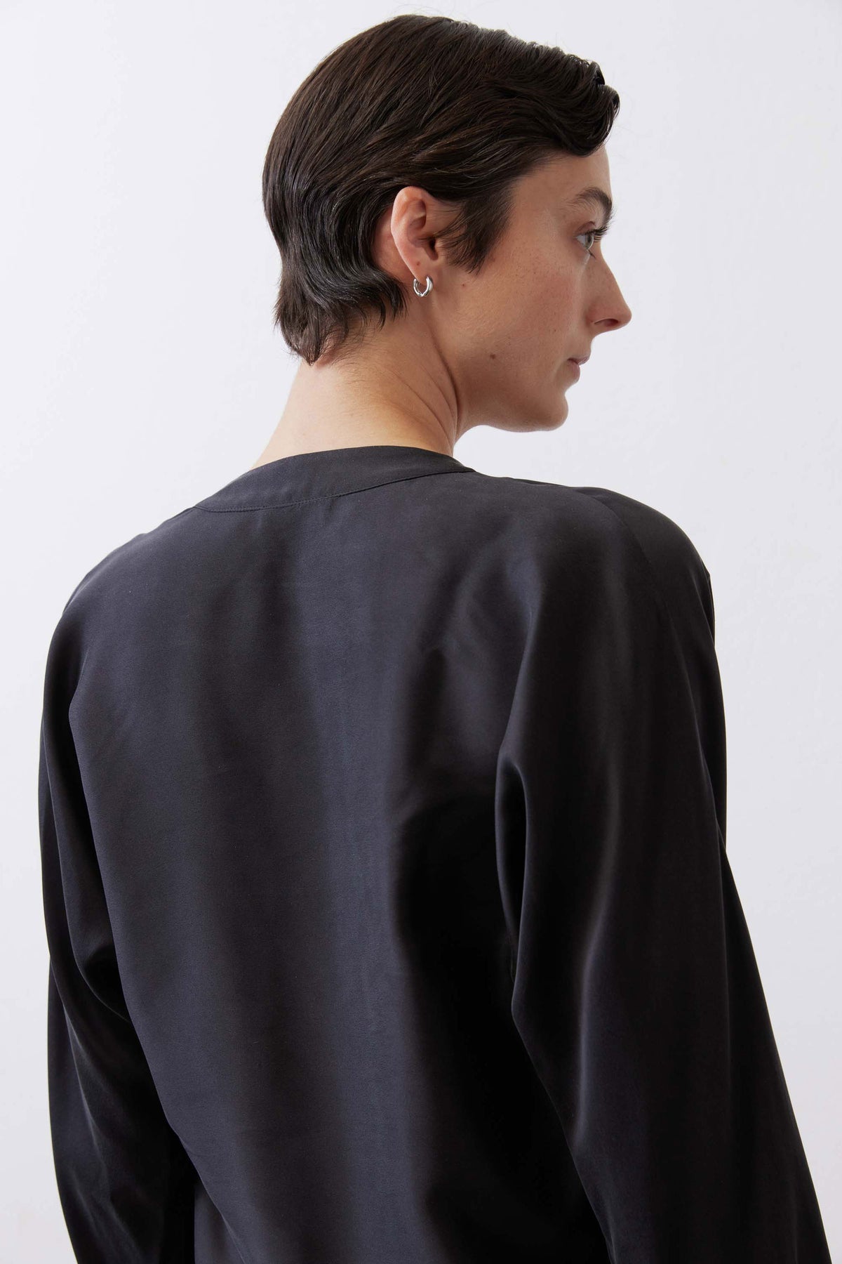 Black long sleeve wrap silk blouse, back view with smooth drape