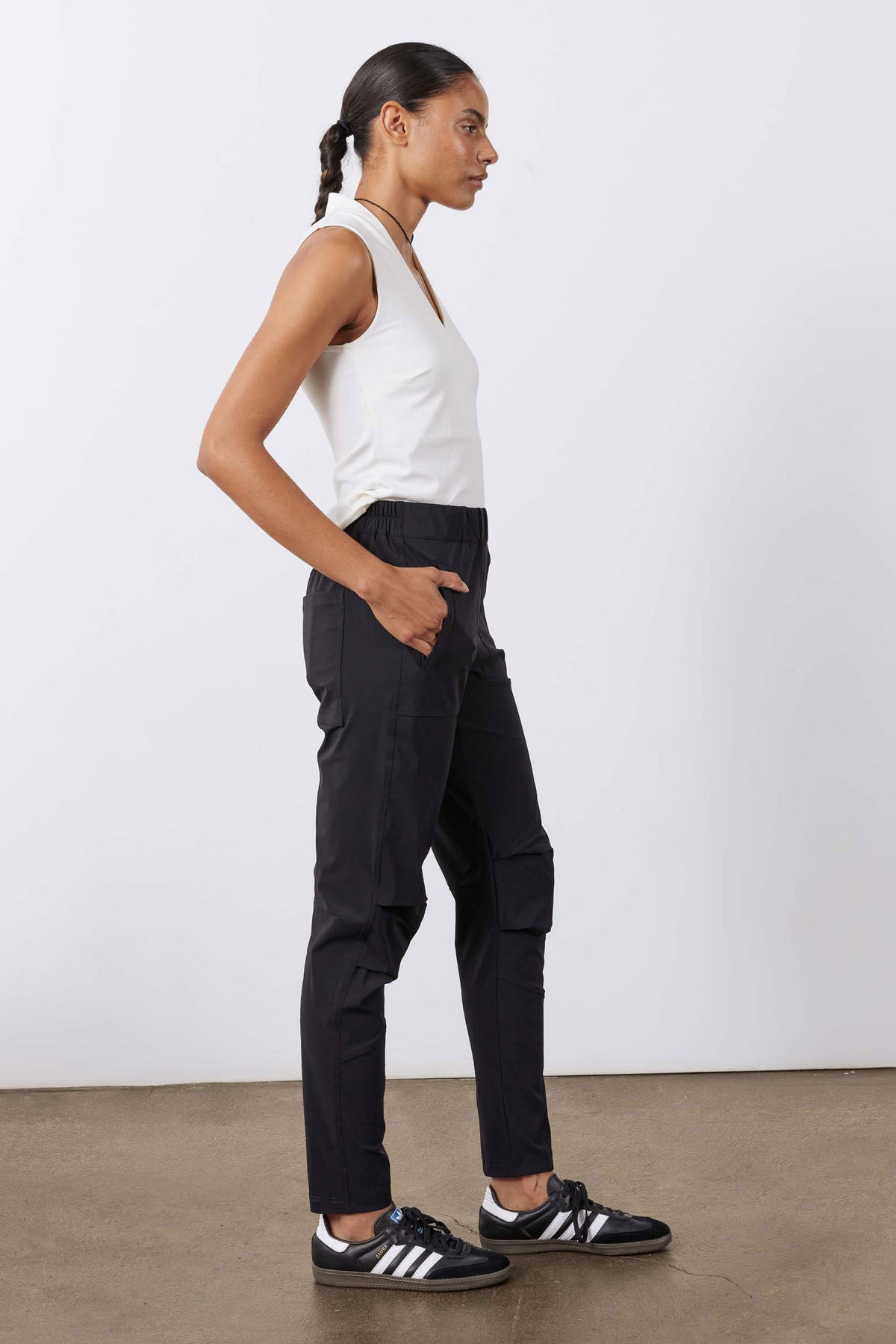 Black active pants with elastic waist, angled thigh pockets, and tapered cuffs