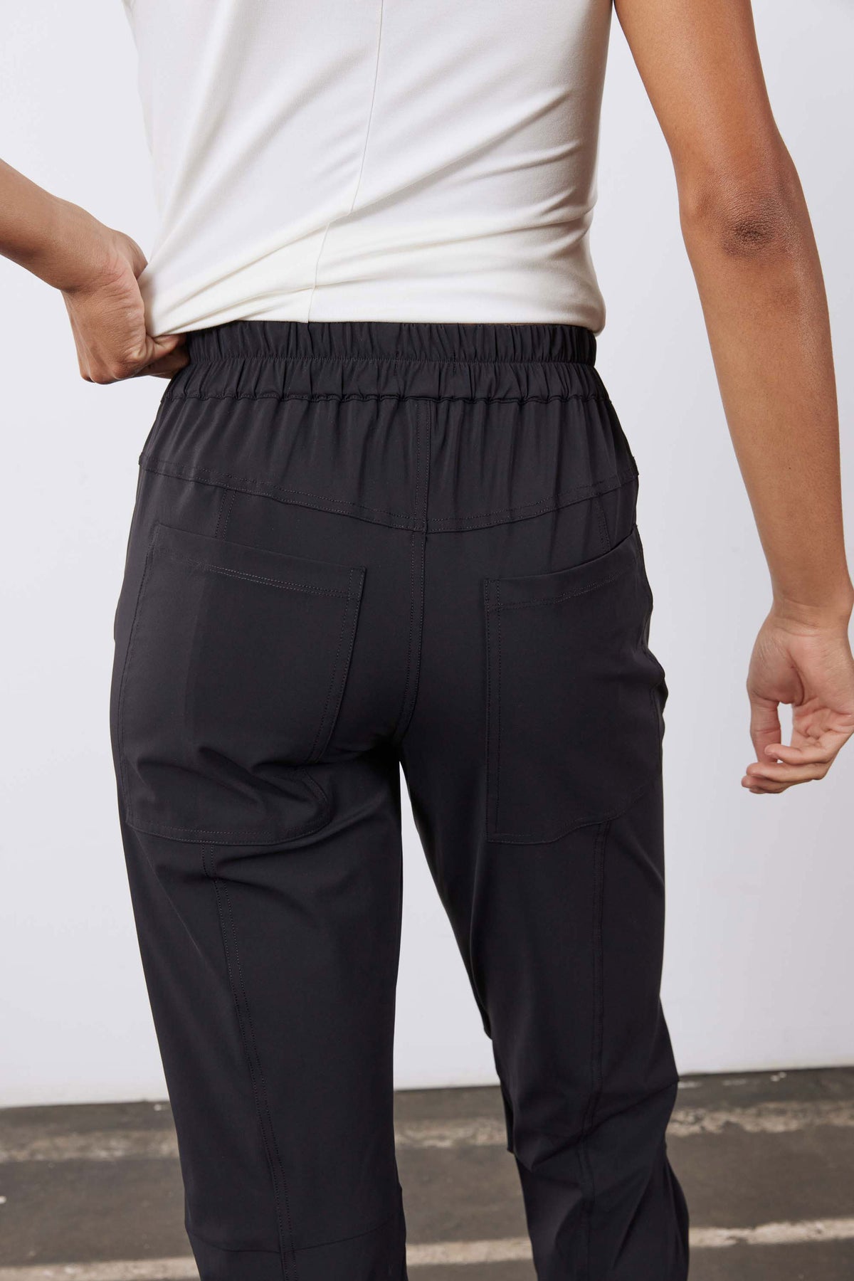 Close-up of black jogger pants waistband with elastic drawstring and side pockets