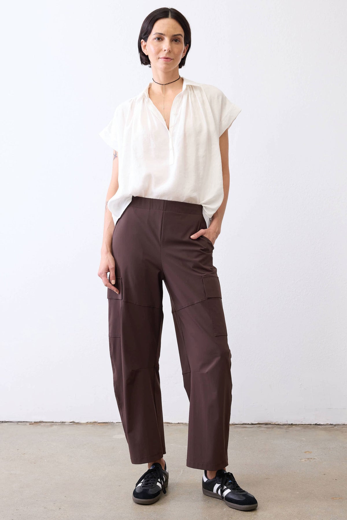 Coffee-brown utility pants with side cargo pockets and relaxed straight-leg silhouette