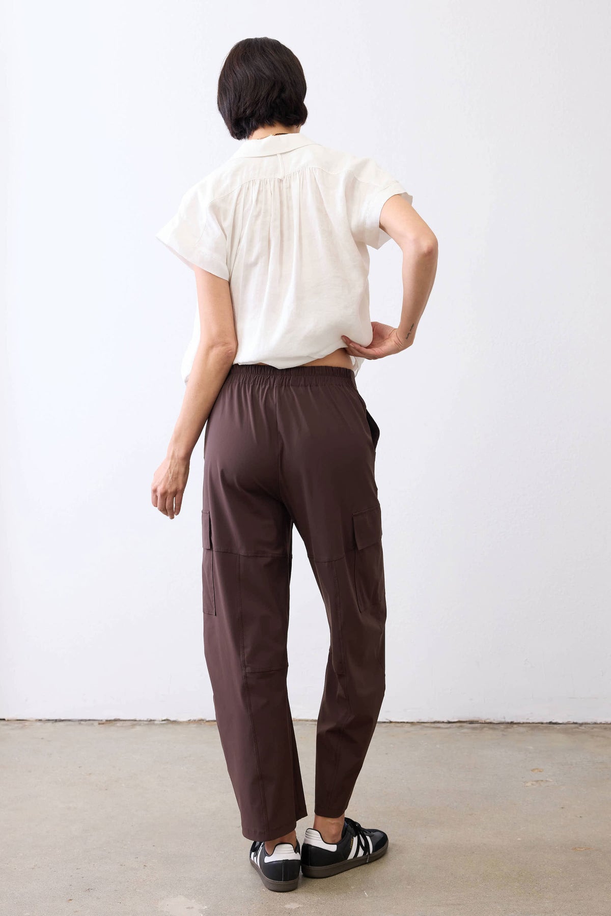 Coffee-brown utility pants from back view, elastic waist and straight-leg cut
